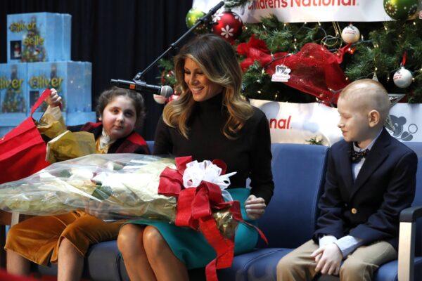 First Lady Melania Trump reacts as she receives gifts from patients Sammie Burley (L) and Declan McCahan (R) after reading a Christmas book to children at Children's National Hospital in Washington, on Dec. 6, 2019. (Jacquelyn Martin/AP Photo)