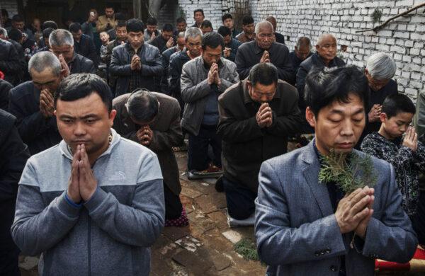 Chinese Catholic worshippers kneel and pray during Palm Sunday Mass during the Easter Holy Week at an "underground" or "unofficial" church near Shijiazhuang, Hebei Province, China, on April 9, 2017. China, an officially atheist country, places a number of restrictions on Christians, allowing legal practice of the faith only at state-approved churches. The policy has driven an increasing number of Christians and Christian converts "underground" to secret congregations in private homes and other venues. (Kevin Frayer/Getty Images)