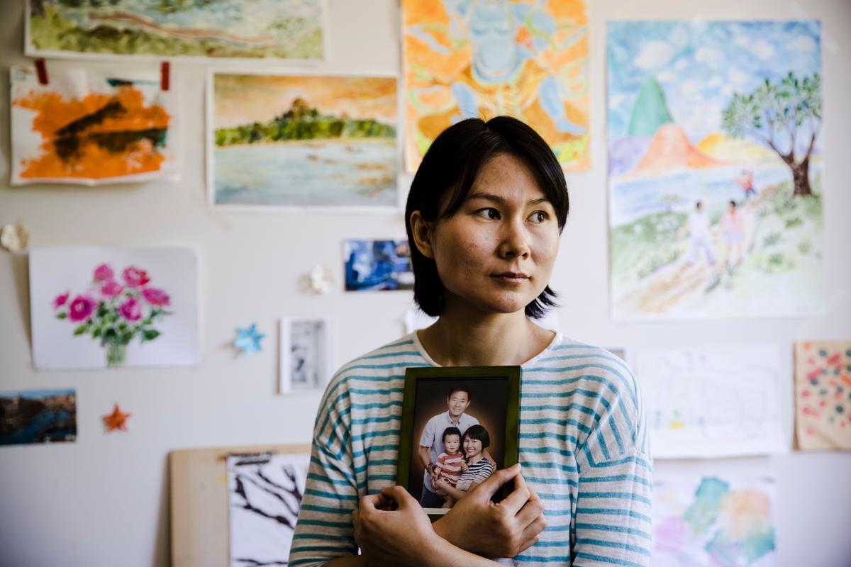 In this May 9, 2018 file photo, Hua Qu, the wife of detained Chinese-American Xiyue Wang, poses for a photograph with a portrait of her family in Princeton, N.J. (Matt Rourke/AP Photo)