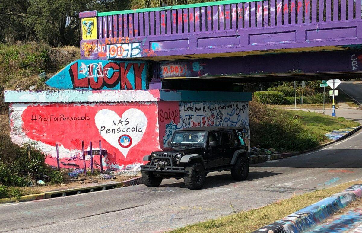 A vehicle drives by a tribute to victims of the Naval Air Station Pensacola that was freshly painted on what’s known as Graffiti Bridge in downtown Pensacola, Fla., on Dec. 7, 2019. (Brendan Farrington/AP Photo)