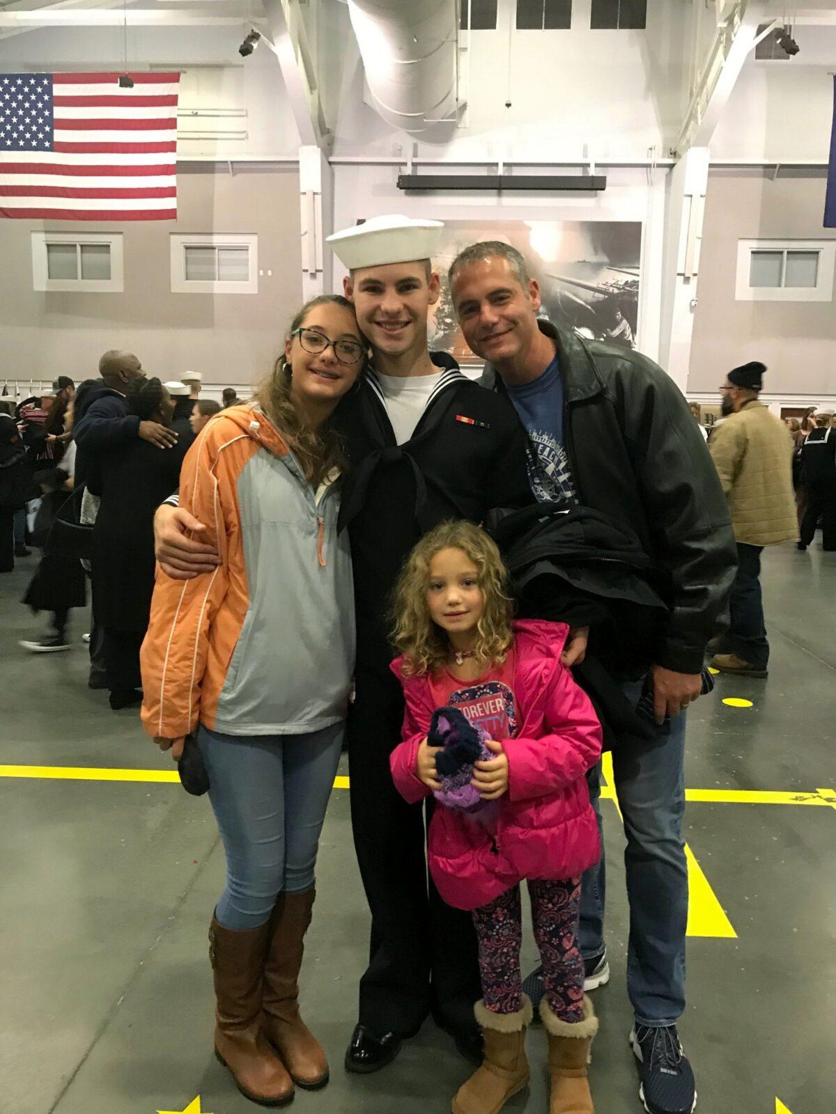 Cameron Walters (C) in Navy uniform, poses for a photo with his sisters and father, on Nov. 22, 2019, the day he graduated from boot camp in Great Lakes, Ill. (Heather Walters/Courtesy of the Walters Family via AP)
