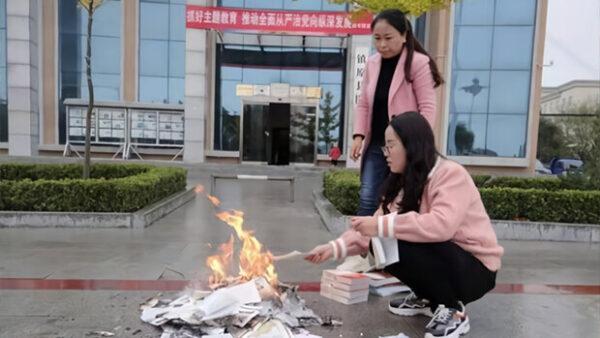 Two workers are seen burning books in front of the Zhenyuan county library in Qingyang City, Gansu Province in the morning of Oct. 22, 2019. (Zhenyuan County official website)