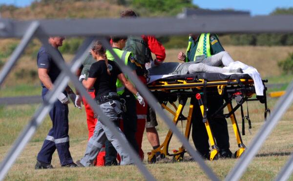 Emergency services attend to an injured person arriving at the Whakatane Airfield after the volcanic eruption on White Island, New Zealand on Dec. 9, 2019, (Alan Gibson/New Zealand Herald via AP)