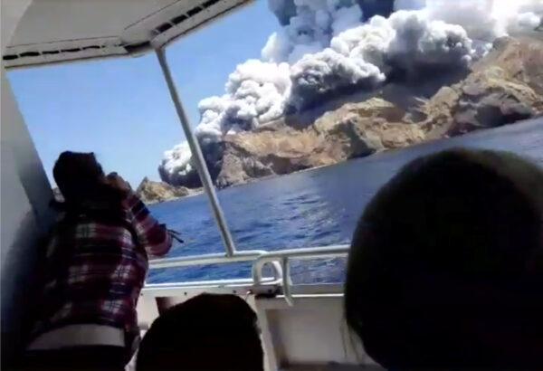 People on a boat react as smoke billows from the volcanic eruption of Whakaari, also known as White Island, New Zealand on Dec. 9, 2019. (Instagram @allessandrokauffmann/via Reuters)