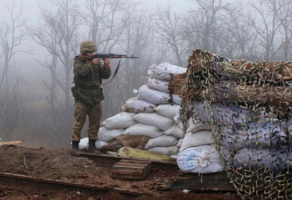 A Ukrainian soldier takes a position on the front line at the town of Novoluhanske in the Donetsk region, Ukraine, Monday, Dec. 9, 2019. (Vitali Komar/ AP Photo)