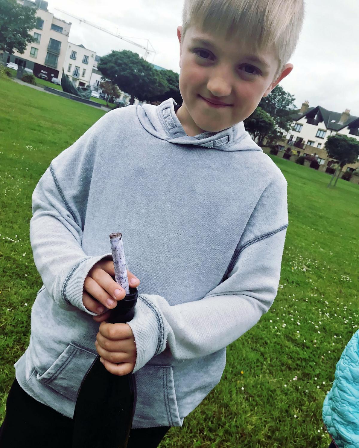 Timur Timondegus, 8, with the mysterious letter in a bottle dated from 2001 that washed up on a beach in Ireland. (©SWNS)