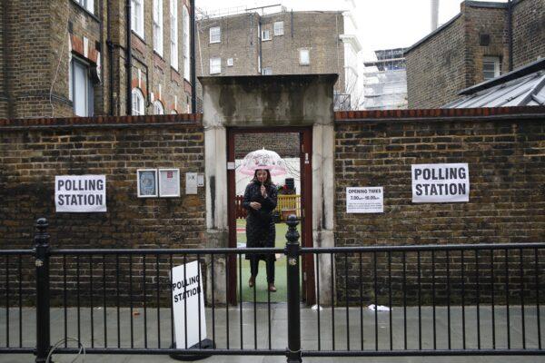 A woman leaves a polling station in London on Dec. 12, 2019. (Thanassis Stavrakis/AP Photo)