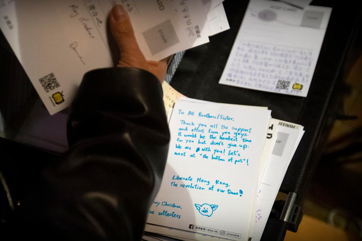 A volunteer sorts cards for detained and jailed protesters at a rally in Hong Kong on Dec. 12, 2019. Protesters in Hong Kong have written hundreds of Christmas cards for detainees jailed in the city's pro-democracy movement. (Mark Schiefelbein/AP Photo)