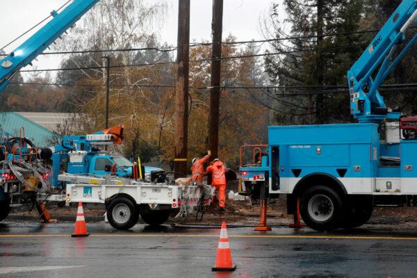 PG&E works on power lines to repair damage caused by the Camp Fire in Paradise, Calif., on Nov. 21, 2018. (Elijah Nouvelage/Reuters)