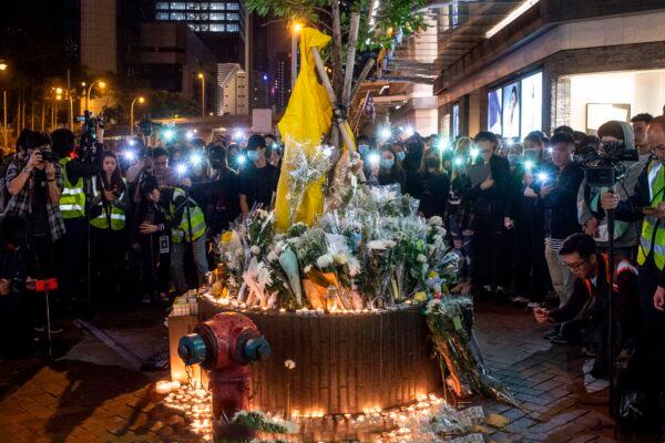 People light their mobiles phones in memory of protester Marco Leung who fell to his death on June 15, at a six-month anniversary memorial outside the Pacific Place shopping mall where he died, in Admiralty in Hong Kong on December 15, 2019. (Philip Fong/AFP via Getty Images)