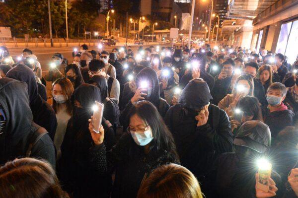 People flash their cellphone lights at a memorial service outside of a local shopping mall Pacific Place in Admiralty, Hong Kong, on Dec. 15, 2019. (Sung Pi Lung/The Epoch Times)