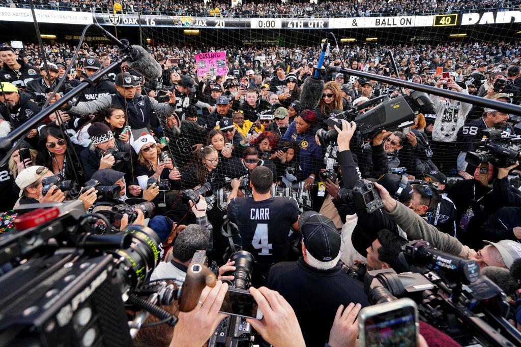 Derek Carr #4 of the Oakland Raiders signs autographs for young fans after the game against the Jacksonville Jaguars at RingCentral Coliseum in Oakland, California on Dec. 15, 2019. (Photo by Daniel Shirey/Getty Images)