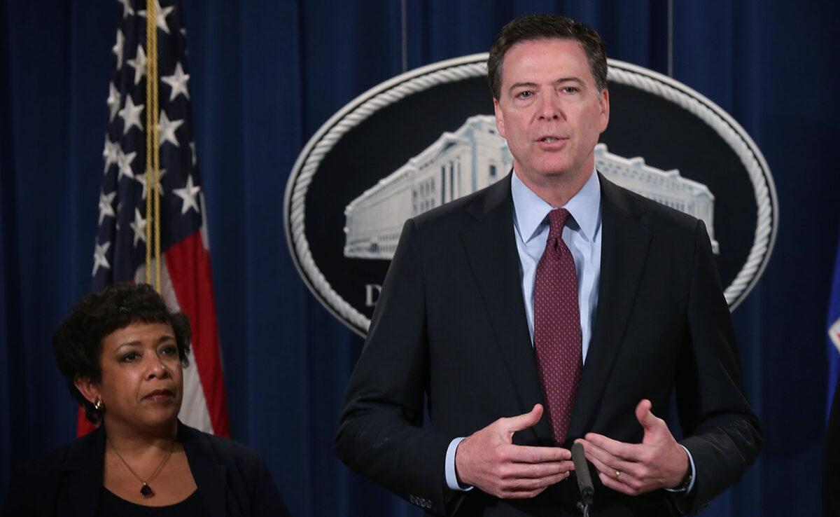 FBI Director James Comey (2nd L) speaks as U.S. Attorney General Loretta Lynch (L) listens during a news conference for announcing a law enforcement action March 24, 2016 in Washington. (Alex Wong/Getty Images)