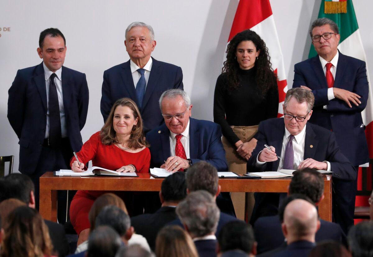 Deputy Prime Minister of Canada Chrystia Freeland (L), Mexico's top trade negotiator Jesus Seade (C), and U.S. Trade Representative Robert Lighthizer, sign an update to the North American Free Trade Agreement, at the national palace in Mexico City on, Dec. 10. 2019. Observing from behind are Mexico's Treasury Secretary Arturo Herrera (L), Mexico's President Andrés Manuel López Obrador (2nd L) Mexico's Labor Secretary Maria Alcade (3rd L), and Mexican Senate President Ricardo Monreal. (Marco Ugarte/AP Photo)