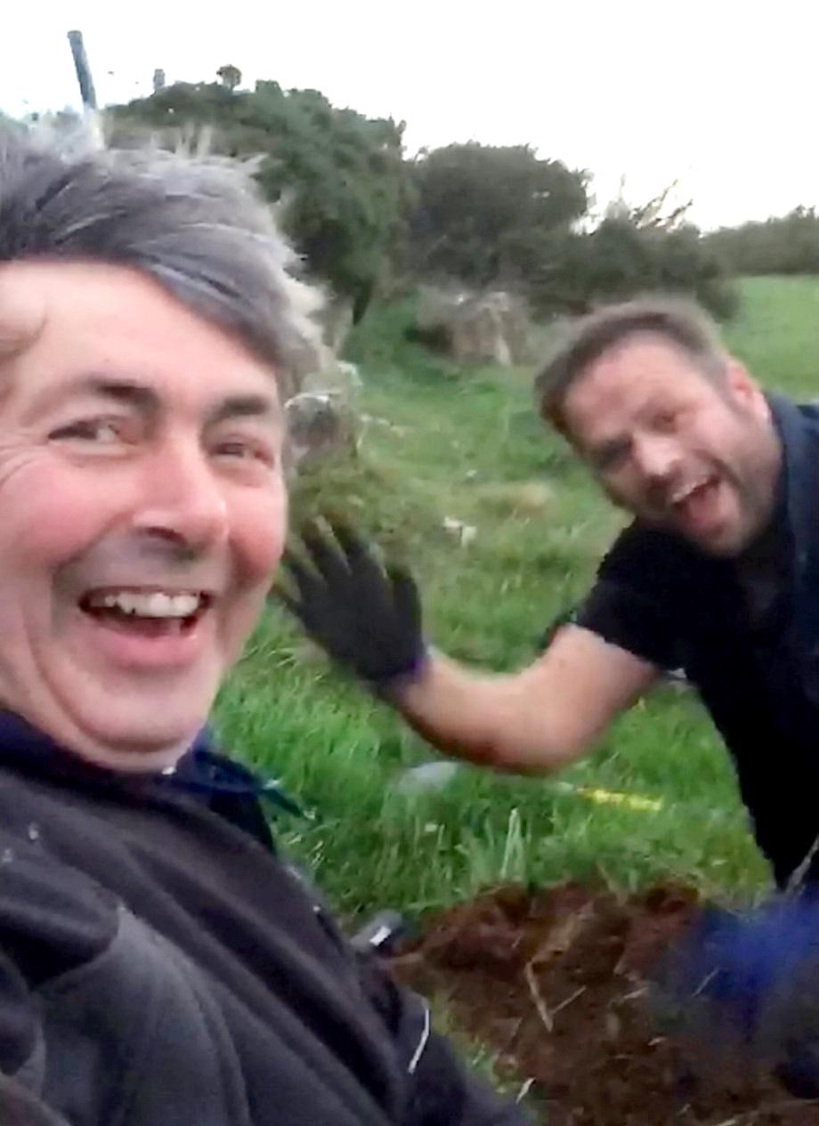 This is the moment two metal detectorists were shocked to find a haul of gold coins. (©SWNS)