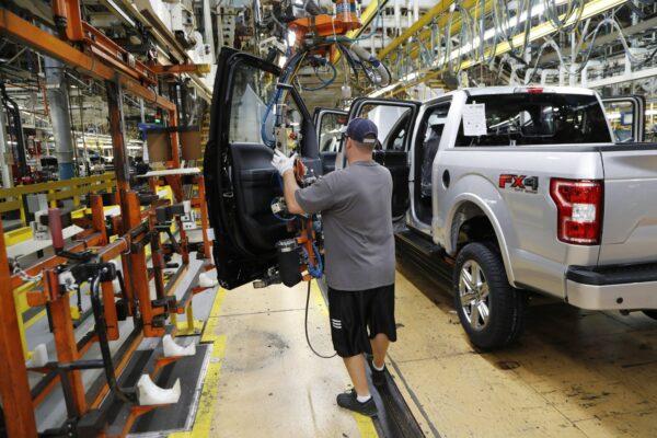 A United Auto Workers assemblyman installs the front doors on a 2018 Ford F-150 truck being assembled at the Ford Rouge assembly plant in Dearborn, Mich., on Sept. 27, 2018. (Carlos Osorio/AP Photo)