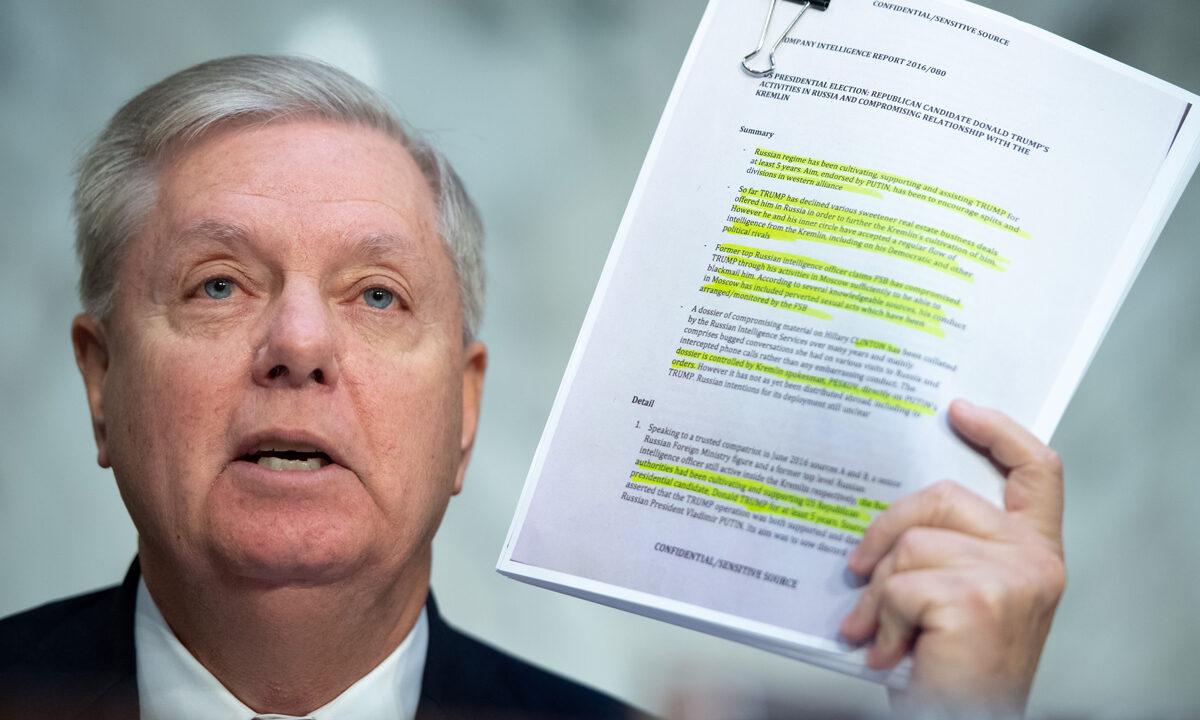 Chairman of the Senate Judiciary Committee Lindsey Graham (R-S.C.) holds a copy of the Steele Dossier during a Senate Judiciary Committee hearing on Capitol Hill on Dec. 11, 2019. (Saul Loeb/AFP via Getty Images)