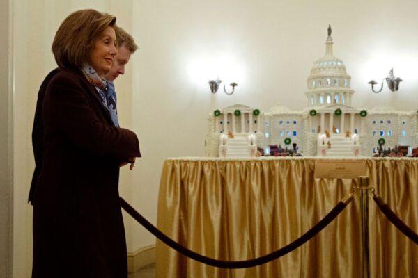 Speaker of the House Nancy Pelosi (D-Calif.) walks past a gingerbread model of the U.S. Capitol as she arrives at the U.S.Capitol, alongside her Press Secretary Drew Hammill, on Dec. 18, 2019. (Chip Somodevilla/Getty Images)