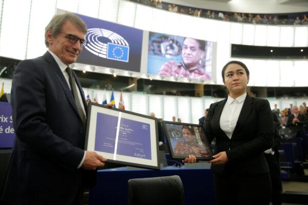 European Parliament President David-Maria Sassoli stands next to Jewher Ilham, daughter of Ilham Tohti, Uyghur economist and human rights activist, holding a portrait of her father during the award ceremony for his 2019 EU Sakharov Prize next to at the European Parliament in Strasbourg, France, on Dec. 18, 2019. (Vincent Kessler/Reuters)