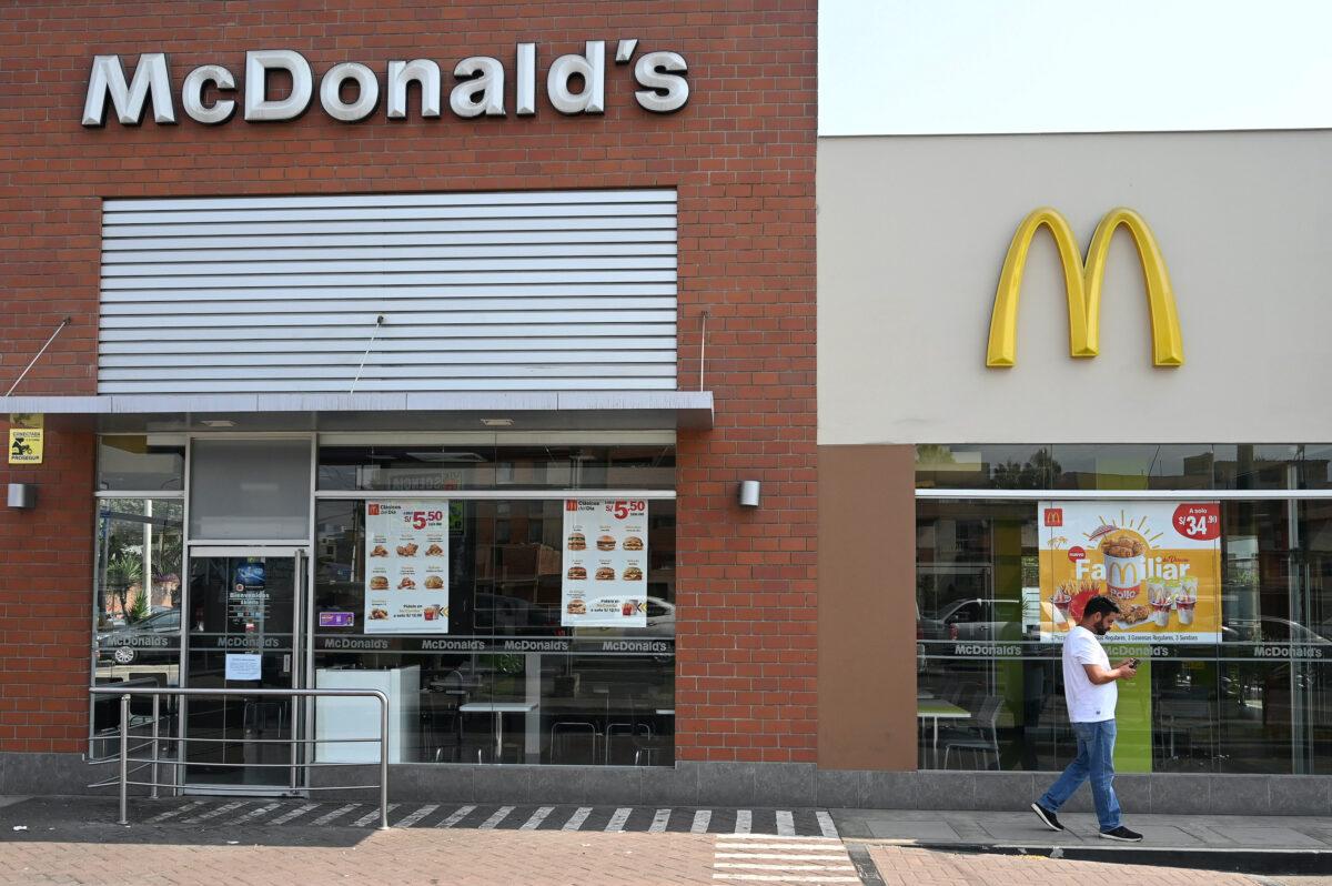A person walks next to a closed McDonald's restaurant, one of all 29 locations that were closed following the deaths of two teenage employees, in Lima, Peru, on Dec. 18, 2019. (Guadalupe Pardo/Reuters)