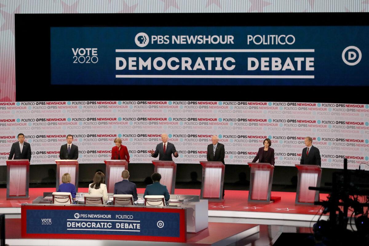 Democratic presidential candidate former Vice President Joe Biden, center speaks as (left to right) former tech executive Andrew Yang, South Bend Mayor Pete Buttigieg, Sen. Elizabeth Warren (D-Mass.), Sen. Bernie Sanders (I-Vt.), Sen. Amy Klobuchar (D-Minn.) and billionaire Tom Steyer listen during the Democratic presidential primary debate at Loyola Marymount University in Los Angeles, California on Dec. 19, 2019. Seven candidates out of the crowded field qualified for the 6th and last Democratic presidential primary debate of 2019. (Mario Tama/Getty Images)