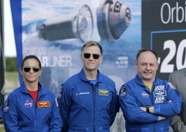 NASA astronaut Nicole Mann, left, Boeing astronaut Chris Ferguson, center, and NASA astronaut Mike Fincke stand in front of the countdown clock during a press conference at the Kennedy Space Center, in Cape Canaveral, Fla., on Dec. 19, 2019. (Terry Renna/AP Photo)