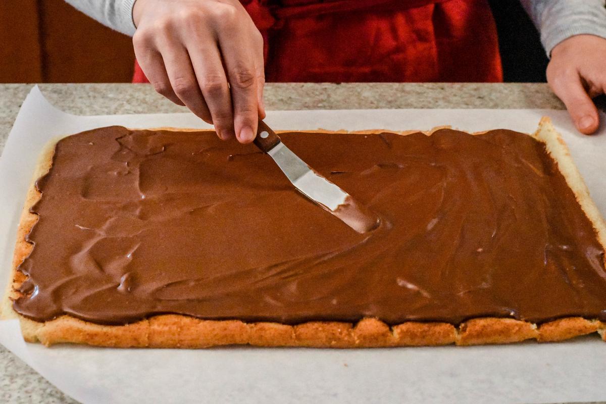 Spread the chocolate buttercream evenly onto the entire sheet of cake. (Audrey Le Goff)
