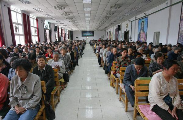 Christians pray during a mass at a church in Xining, Qinghai Province, northwest China, on July 3, 2005. China officially sanctions five religious groups: Protestantism, Catholic Christianity, Islam, Buddhism, and Taoism. Chinese are allowed to worship only in state-sanctioned churches and temples. (China Photos/Getty Images)