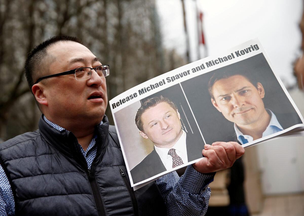 A man holds a placard calling for China to release Canadian detainees Michael Spavor and Michael Kovrig outside a court hearing for Huawei executive Meng Wanzhou at the B.C. Supreme Court in Vancouver, Canada, on March 6, 2019. (Lindsey Wasson/Reuters)