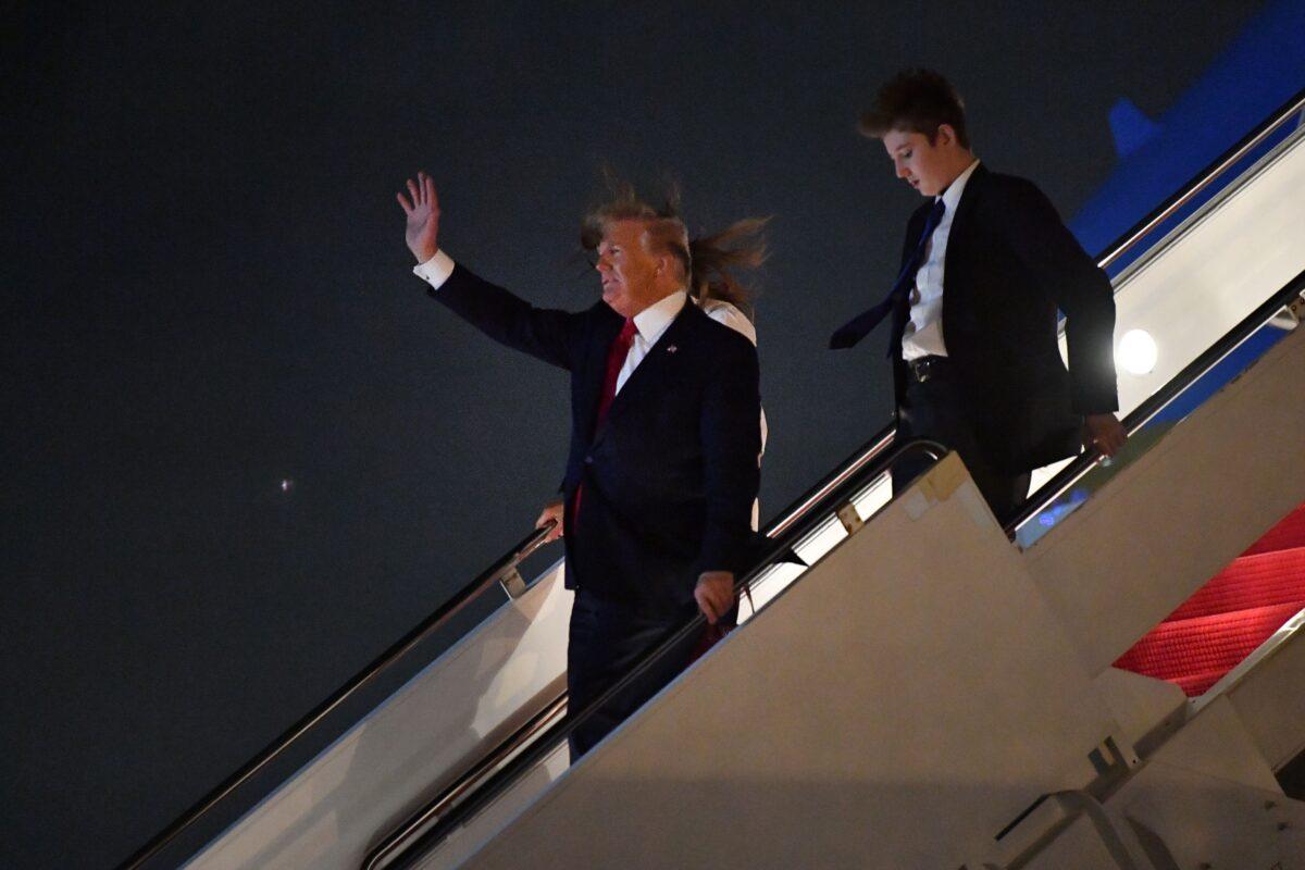President Donald Trump waves as he, First Lady Melania Trump, and their son Barron Trump arrive at Palm Beach International Airport in West Palm Beach on Dec. 20, 2019. (Nicholas Kamm/AFP via Getty Images)