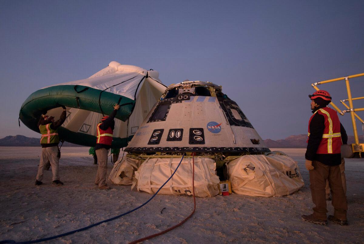 Boeing, NASA, and U.S. Army personnel work around the Boeing CST-100 Starliner spacecraft shortly after it landed in White Sands, N.M, on Dec. 22, 2019. (Bill Ingalls/NASA)
