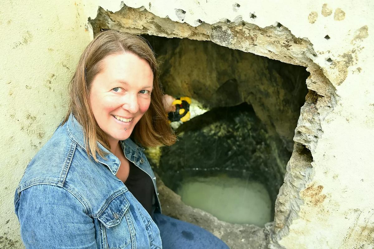 Alice Crawford taking a look inside the well. (SWNS)