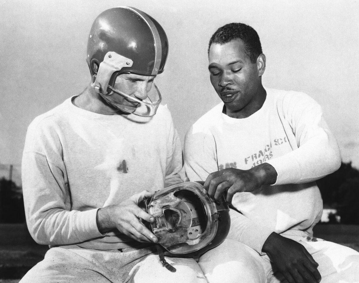 San Francisco 49ers fullback Joe Perry, right, shows quarterback Y. A. Tittle the plastic mask he has worn during the football season to protect his bridgework, during practice at Menlo Park, Calif. Tittle, who suffered a cheekbone fracture against the Detroit Lions, is wearing the mask he has used since. Helmets have evolved from the original hard leather of the NFL’s infancy to hard polycarbonate single-piece shells with various amounts of padding and air bladders that served as the primary form of head protection into the beginning of this century. (AP Photo/File)