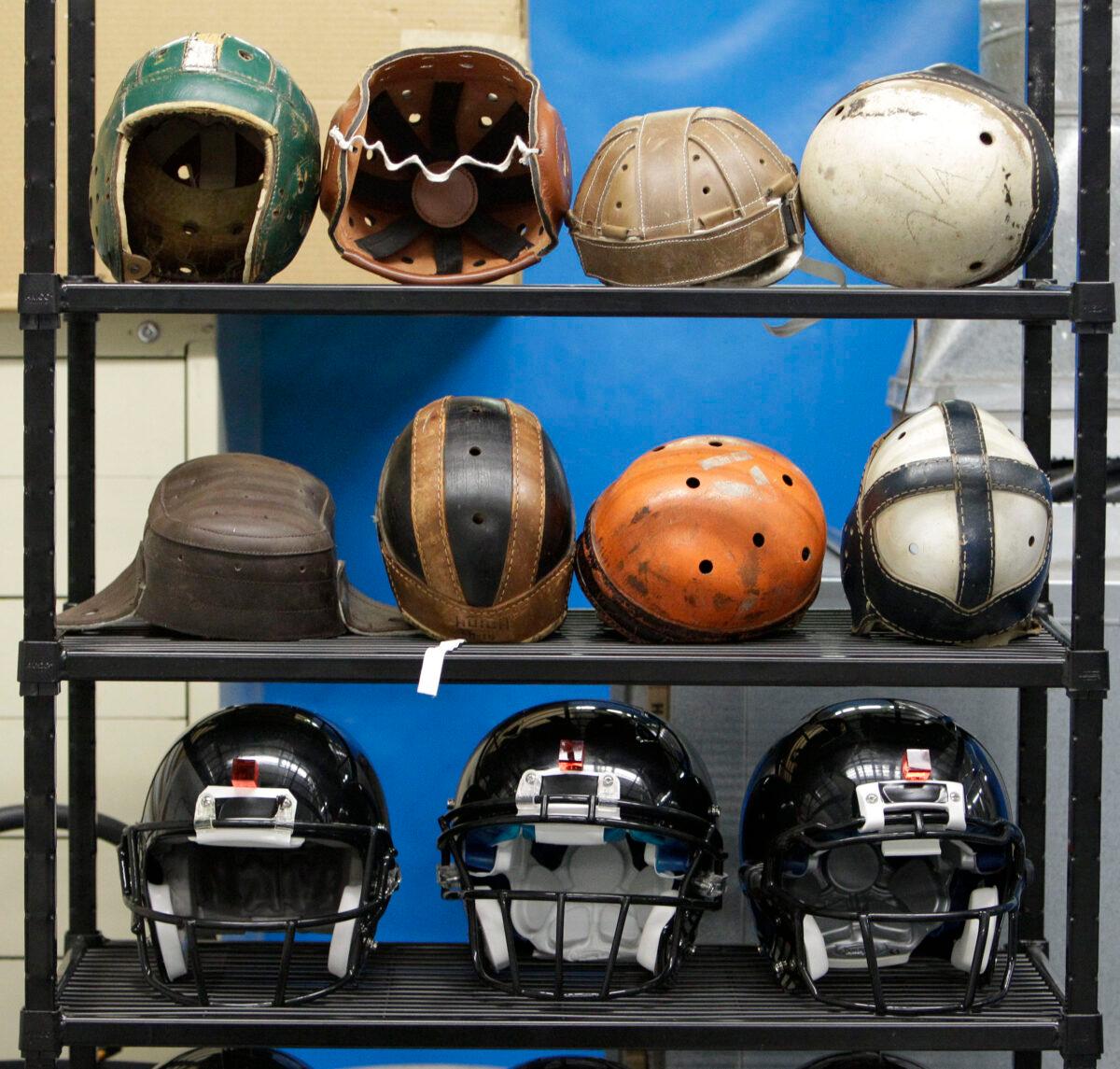 Various football helmets, used for testing helmet-to-helmet collisions, are displayed on a rack at a laboratory in the Cleveland Clinic's Lutheran Hospital in Cleveland. Helmets have evolved from the original hard leather of the NFL’s infancy to hard polycarbonate single-piece shells with various amounts of padding and air bladders that served as the primary form of head protection into the beginning of this century taken on Sept. 23, 2010. (Mark Duncan/AP-File)
