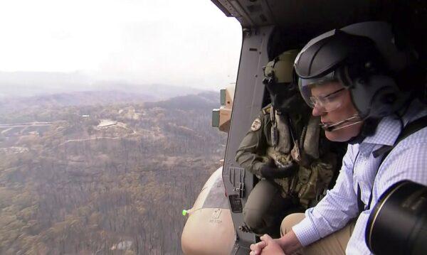In this image made from video, Australia's Prime Minister Scott Morrison looks at fire damage from helicopter near Gospers Mountain, New South Wales, on Dec. 23, 2019. (Australian Pool via AP)