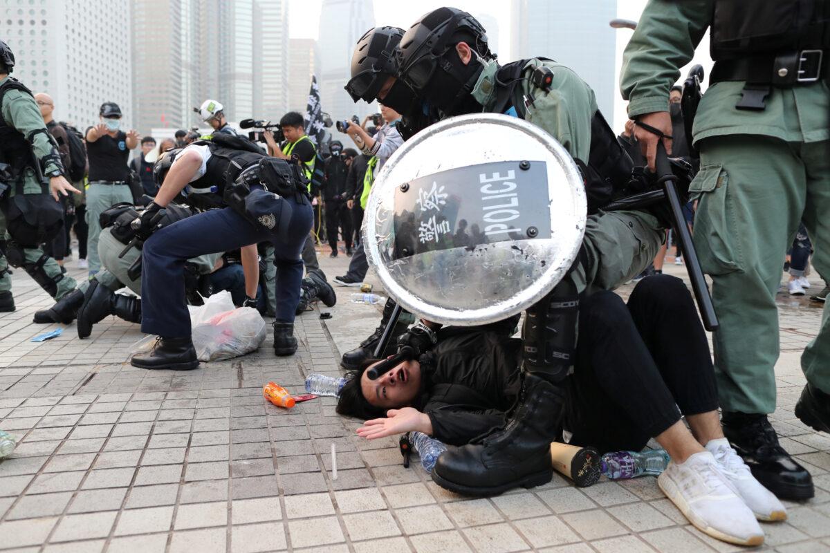 Police arrest a Hong Kong protester after a Chinese flag was removed from a flag pole at a rally in support of Xinjiang Uyghurs' human rights in Hong Kong, China on Dec. 22, 2019. (Lucy Nicholson/Reuters)