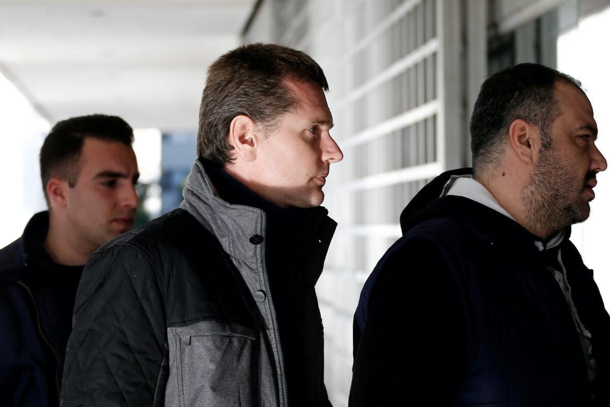 FILE PHOTO: Alexander Vinnik, a 38-year-old Russian man suspected of running a money-laundering operation using bitcoin, is escorted by police officers to a court in Athens, Greece, on Dec. 13, 2017. (Costas Baltas/Reuters-File)
