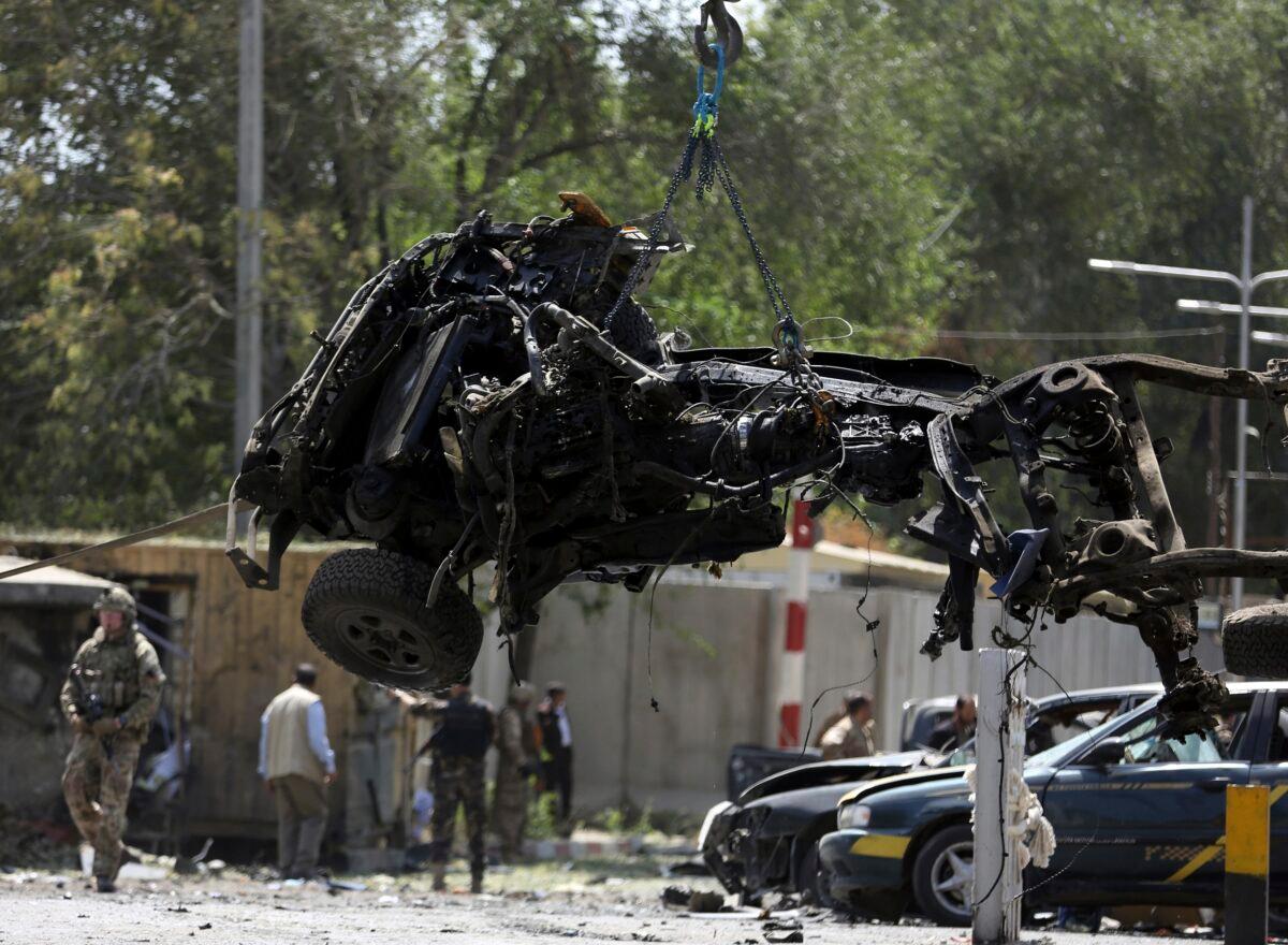 Resolute Support (RS) forces remove a destroyed vehicle after a car bomb explosion in Kabul, Afghanistan on Sept. 5, 2019. (Rahmat Gul/AP Photo)