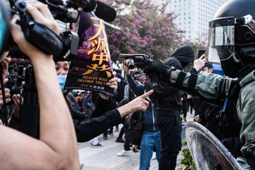 Facing the Barrel of a Gun, Woman Holds Epoch Times Poster to Protest Hong Kong Police