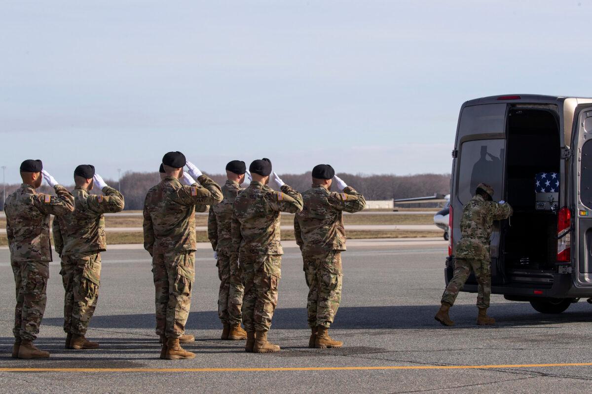 An Army carry team salutes a transfer case containing the remains of U.S. Army Sgt. 1st Class Michael Goble, as U.S. Air Force Tech. Sgt. Shaquita Darby closes the door, at Dover Air Force Base, Del. on Wednesday, Dec. 25, 2019. (Alex Brandon/AP)