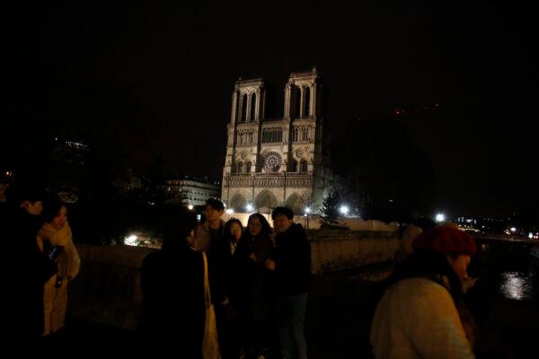 Tourists take selfies in front of Notre Dame cathedral in Paris, on Dec. 24, 2019. (Thibault Camus/AP)
