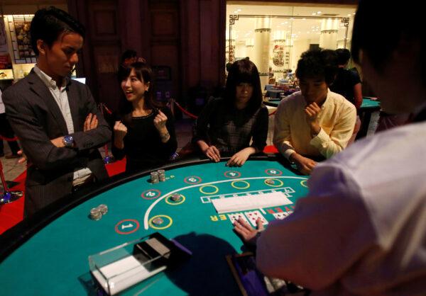 Visitors react after they win a mock baccarat casino game at an international tourism promotion symposium in Tokyo, Japan, on Sept. 28, 2013. (Yuya Shino/Reuters)