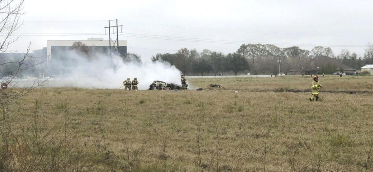 First responders looking over the site of a plane crash near Feu Follet Road and Verot School Road in Lafayette, La., on Dec. 28, 2019. (AcadianNews via AP)