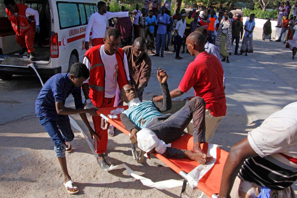 Medical personnel carry a civilian who was wounded in suicide car bomb attack at check point in Mogadishu, Somalia, on Dec, 28, 2019. (Farah Abdi Warsame/AP Photo)