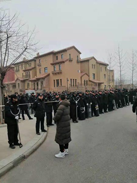Hundreds of self-proclaimed security guards in black uniforms are guarding the security gates of the community 24 hours a day. They intimidate residents, forcing them to move out by Dec. 31 of 2019. (Courtesy of Mr. Li, a resident)