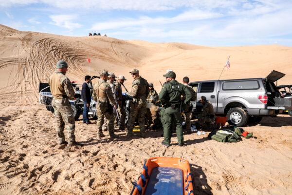 Border Patrol BORSTAR agents tend to an injured man who crashed his Polaris RZR sand car in the Imperial Sand Dunes near the U.S.-Mexico border, Calif., on Nov. 30, 2019. (Charlotte Cuthbertson/The Epoch Times)