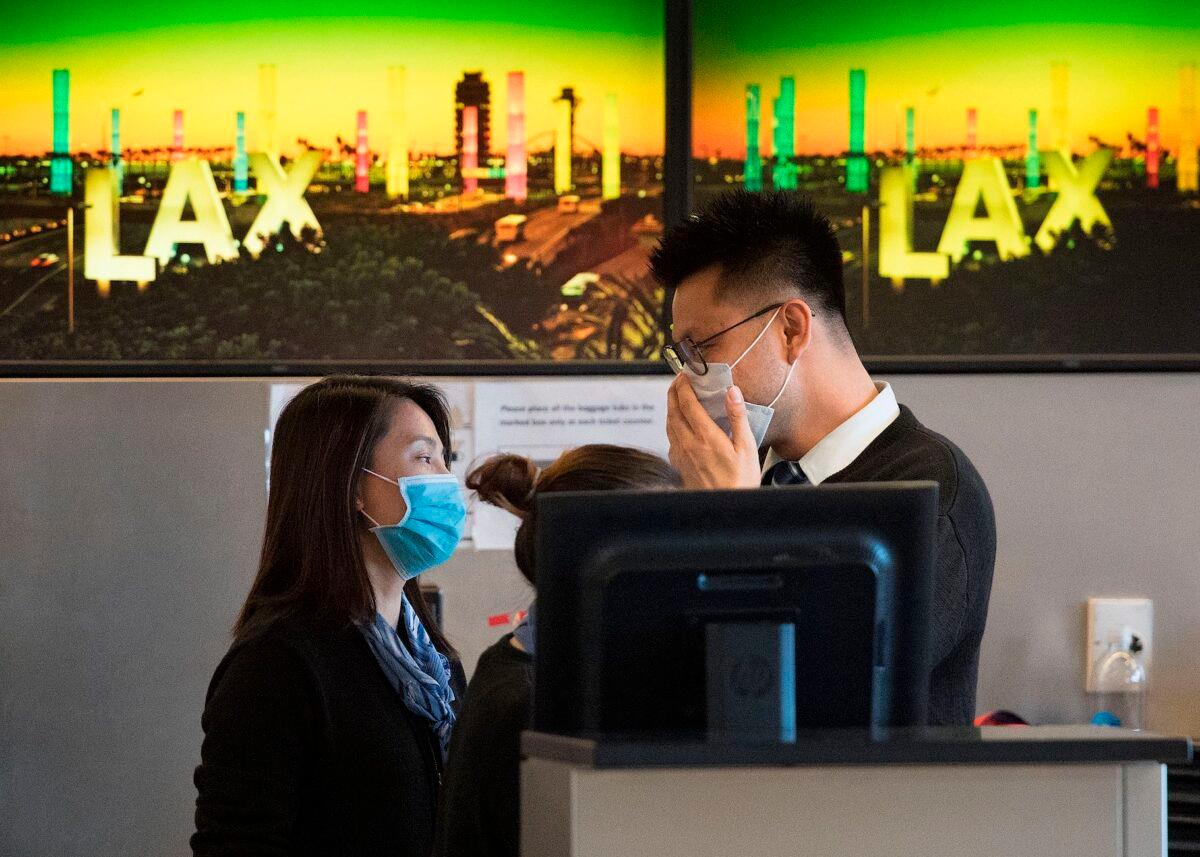 Airline check in staff wear face masks to protect against the spread of the Coronavirus at the Los Angeles International Airport, California, on Jan. 29, 2020. (Mark Ralston/AFP via Getty Images)