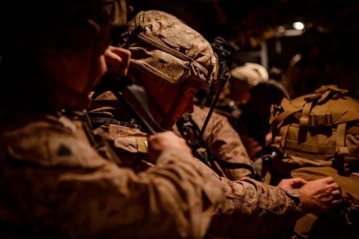 In this photo provided by U.S. Department of Defense, U.S. Marines assigned to Special Purpose Marine Air-Ground Task Force-Crisis Response-Central Command (SPMAGTF-CR-CC) 19.2, prepare to deploy from Kuwait in support of a crisis response mission on Dec. 31, 2019. (U.S. Marine Corps photos by Sgt. Robert G. Gavaldon via AP)
