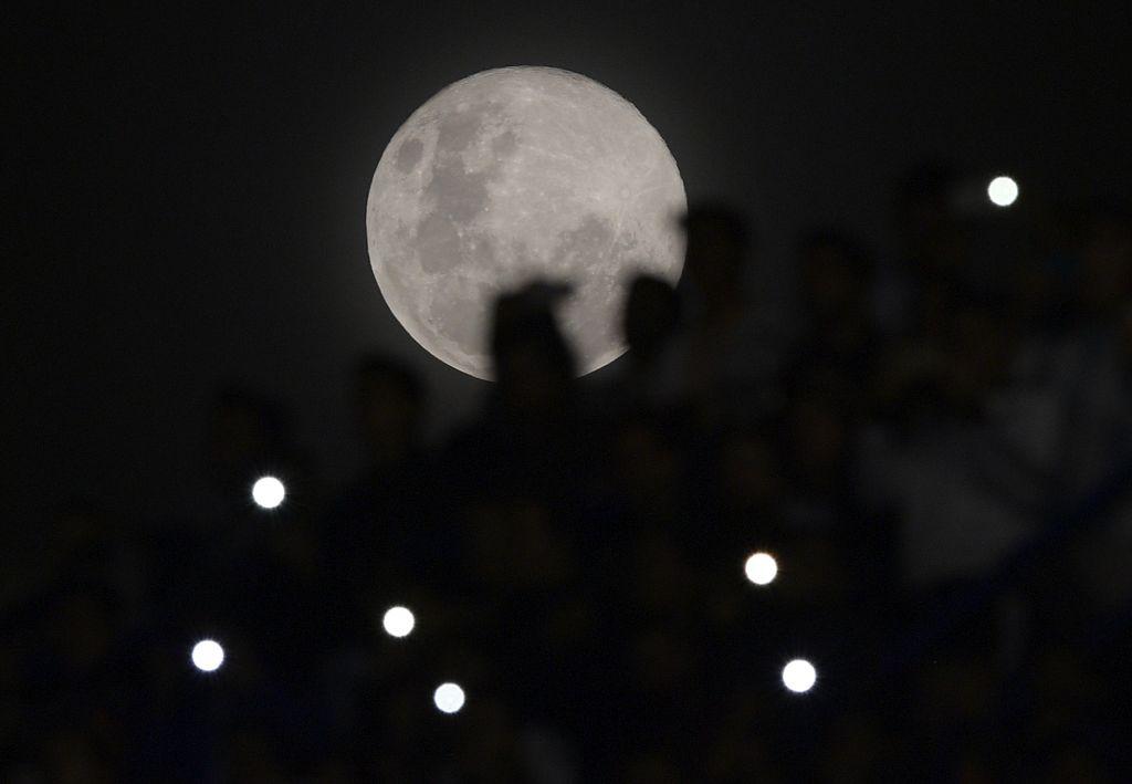 The full moon seen by soccer fans at a match between Argentina and Haiti at Boca Juniors' stadium La Bombonera in Buenos Aires on May 29, 2018 (©Getty Images | <a href="https://www.gettyimages.com/detail/news-photo/the-full-moon-is-seen-as-fans-watch-the-international-news-photo/963629536?adppopup=true">JUAN MABROMATA</a>)