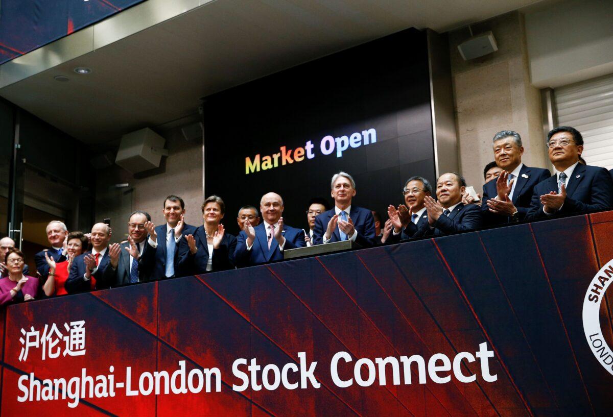 Britain's then-Chancellor of the Exchequer Philip Hammond (C) and Chinese Vice-Premier Hu Chunhua (C-R) applaud the launch of a stock link between the Shanghai and London stock exchanges, in London, on June 17, 2019. (Henry Nicholls/AFP via Getty Images)